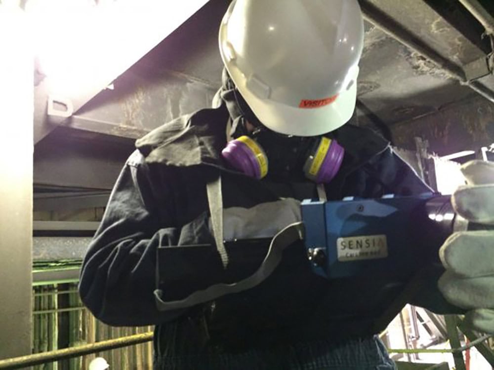 Smart LDAR technician inspecting SO2 emissions monitoring device.