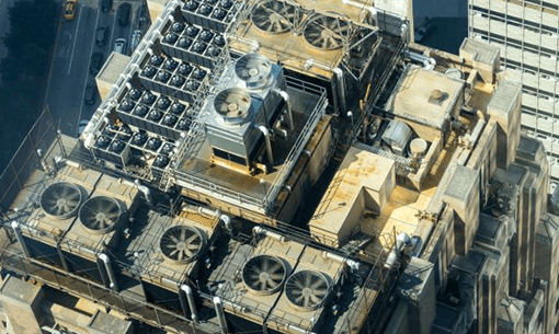Industrial HVAC units reducing refrigerant gas emissions on a city rooftop.