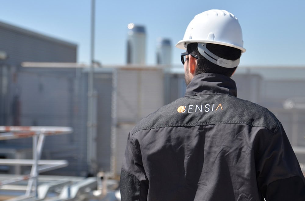 Worker in safety gear inspecting industrial environment for HSE compliance.